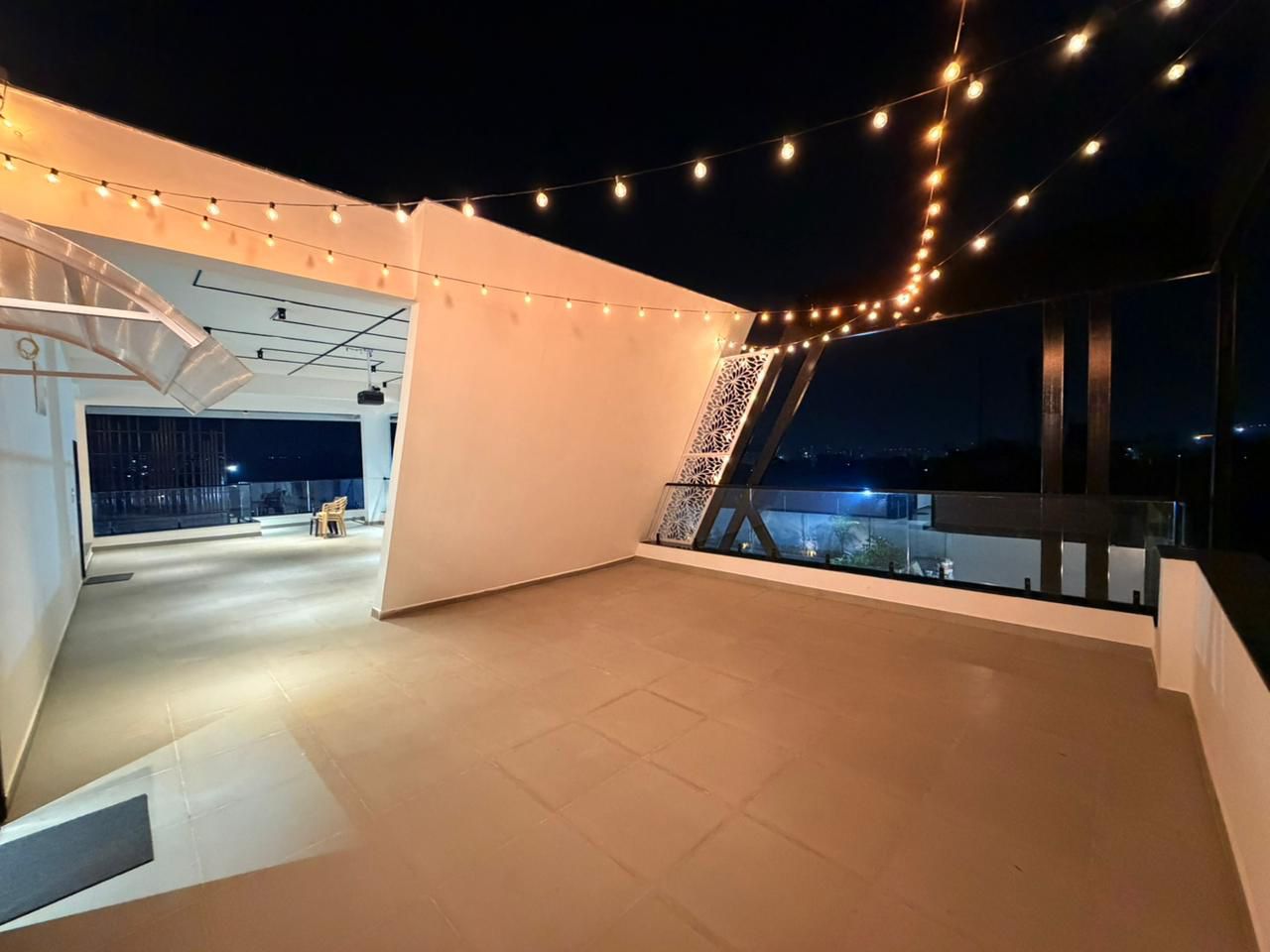 Starlit string-light terrace at night at D Treatfarms private farmhouse Pocharam